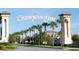 The grand entrance to Champions Gate features stately pillars, lush landscaping, and a welcoming archway for visitors at 1868 Sanibel Dr, Davenport, FL 33896