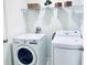 Convenient laundry room with washer, dryer, and overhead shelving at 1868 Sanibel Dr, Davenport, FL 33896