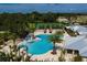 Aerial view of the community pool, featuring palm trees, tennis courts, and a splash pad at 1872 Summer Serenity Dr, Kissimmee, FL 34744