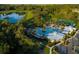 Aerial view of a community pool, pond, and tennis courts surrounded by lush landscaping at 1872 Summer Serenity Dr, Kissimmee, FL 34744