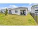 Home backyard with a covered patio area and lush green lawn, enclosed by a fence at 1872 Summer Serenity Dr, Kissimmee, FL 34744