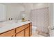 Clean bathroom featuring a wood vanity with quartz countertop, framed mirror, and a shower with patterned curtain at 1872 Summer Serenity Dr, Kissimmee, FL 34744