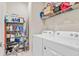 Well-organized laundry room features front load washer, dryer, storage shelves and cleaning supplies at 1872 Summer Serenity Dr, Kissimmee, FL 34744