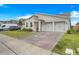 A cozy single-story home with an attached two-car garage and brick-paved driveway at 18863 Rawson St, Orlando, FL 32827