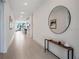 Bright hallway features neutral colors, tile flooring, console table and decor at 18863 Rawson St, Orlando, FL 32827
