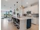 Stylish kitchen with white cabinets, island seating and pendant lighting open to the living area at 18863 Rawson St, Orlando, FL 32827