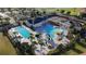 Stunning community pool area featuring a large pool, kiddie pool with slides, and lush tropical landscaping at 195 Preston Ave, Davenport, FL 33837