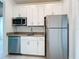 Kitchen features stainless steel appliances, white cabinets, modern hardware, and quartz countertops at 195 Preston Ave, Davenport, FL 33837