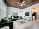 Stylish living room with a plush green sectional, dark wood ceiling, and modern decor at 195 Preston Ave, Davenport, FL 33837