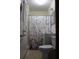 Small bathroom featuring floral shower curtain, light tile walls, and basic fixtures at 206 Willow St, Lake Wales, FL 33859
