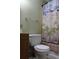 This bathroom includes a toilet and an patterned shower curtain at 206 Willow St, Lake Wales, FL 33859