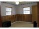 Bedroom featuring wood paneling, tiled floors, and two windows with mini blinds at 206 Willow St, Lake Wales, FL 33859