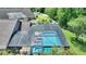 Aerial view of the large screened pool with ample seating area, alongside green landscaping and mature trees at 219 Breezy Oaks Ct, Davenport, FL 33896