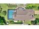 Aerial view of home with screened pool and deck, surrounded by a green lawn and mature trees at 219 Breezy Oaks Ct, Davenport, FL 33896