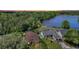 Aerial view of homes by the lake, with lush greenery and well-maintained landscaping at 219 Breezy Oaks Ct, Davenport, FL 33896