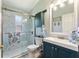 Bathroom featuring a glass-doored shower, modern vanity, and fixtures at 219 Breezy Oaks Ct, Davenport, FL 33896