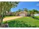 Beautiful home with lush green lawn, mature trees and vibrant flowering plants in a landscaped yard at 219 Breezy Oaks Ct, Davenport, FL 33896