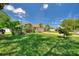 Well-manicured front lawn with flowerbeds and lush landscaping leading up to the house at 219 Breezy Oaks Ct, Davenport, FL 33896
