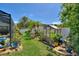 Landscaped backyard with charming greenhouse, perfect for gardening enthusiasts and outdoor living at 219 Breezy Oaks Ct, Davenport, FL 33896
