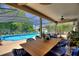 Entertain on the lanai with a dining table near the pool, ceiling fan, and scenic view at 219 Breezy Oaks Ct, Davenport, FL 33896
