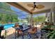 Lounge on the lanai with plush outdoor seating, overlooking the pool and lush greenery at 219 Breezy Oaks Ct, Davenport, FL 33896