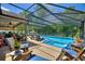 Enjoy the screened pool with an attached spa, outdoor seating, and lush landscaping at 219 Breezy Oaks Ct, Davenport, FL 33896