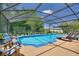 The screened-in pool area features lounge chairs and clear water, perfect for relaxing and soaking up the sun at 219 Breezy Oaks Ct, Davenport, FL 33896
