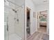 Modern bathroom shower with glass door and white tile, complemented by contemporary fixtures at 219 Breezy Oaks Ct, Davenport, FL 33896