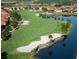 Scenic aerial view of a golf course with ponds, sand traps, and well-maintained green lawns at 223 Bell Tower W Xing, Poinciana, FL 34759