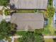 Drone view of the home with brown shingle roof, screen patio, and green landscaping at 223 Bell Tower W Xing, Poinciana, FL 34759