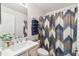 Cozy bathroom featuring a vanity, mirror, and a patterned shower curtain, creating a relaxing atmosphere at 223 Bell Tower W Xing, Poinciana, FL 34759