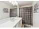 This bathroom has a white vanity with a large mirror and decorative fixtures and a shower at 223 Bell Tower W Xing, Poinciana, FL 34759