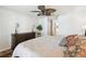 This bedroom is decorated with a ceiling fan, pillows and blankets, lamps, and dressers at 223 Bell Tower W Xing, Poinciana, FL 34759
