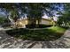 Beautiful home with lush landscaping, a well-manicured lawn, and a golf cart parked in the driveway at 223 Bell Tower W Xing, Poinciana, FL 34759