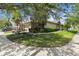Charming single story home with mature trees, lush landscaping, and well-maintained lawn at 223 Bell Tower W Xing, Poinciana, FL 34759