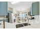 Bright kitchen with stainless steel appliances, blue cabinets, and a large window for natural light at 223 Bell Tower W Xing, Poinciana, FL 34759