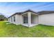 Back of house with covered patio and sliding doors, with large grassy area at 250 Beckenham Dr, Kissimmee, FL 34758