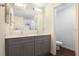 Bathroom featuring double vanity, large mirror, and a separate toilet room at 250 Beckenham Dr, Kissimmee, FL 34758