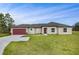 Charming single-story home with a well-maintained lawn, red garage door, and neutral stucco at 250 Beckenham Dr, Kissimmee, FL 34758