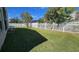 Spacious backyard featuring well-manicured lawn and a secure white picket fence, offering privacy and ample outdoor space at 2713 Barnsley Ln, Kissimmee, FL 34744