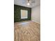 Bright bedroom featuring wood-look floors and an eye-catching accent wall at 2713 Barnsley Ln, Kissimmee, FL 34744