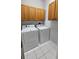 Functional laundry room includes wooden cabinets and white washer and dryer units at 2713 Barnsley Ln, Kissimmee, FL 34744