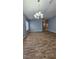 Light-filled living room featuring wood-look tile flooring and modern chandelier at 2713 Barnsley Ln, Kissimmee, FL 34744