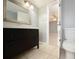 Bathroom view with dark-wood cabinets, sink and commode, doorway leads to bedroom with ceiling fan at 2725 N Poinciana Blvd # 147, Kissimmee, FL 34746