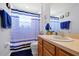 Bathroom with a single sink vanity, toilet, and blue and white striped shower curtain at 2747 Lido Key Dr, Kissimmee, FL 34747