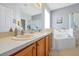 Bathroom featuring a double sink vanity and garden tub with shower and decorative wall tile at 2747 Lido Key Dr, Kissimmee, FL 34747