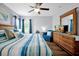 Bright bedroom with wood floors, a ceiling fan, windows, and a comfortable seating area at 2747 Lido Key Dr, Kissimmee, FL 34747