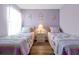 Bedroom showcasing twin beds with colorful bedding, side table, and laminate flooring at 2747 Lido Key Dr, Kissimmee, FL 34747