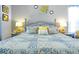 Bedroom features queen bed with yellow and gray pillows with matching side table lamps at 2747 Lido Key Dr, Kissimmee, FL 34747