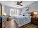 Cozy bedroom with wood floors, a ceiling fan, and a comfortable seating area by the window at 2747 Lido Key Dr, Kissimmee, FL 34747